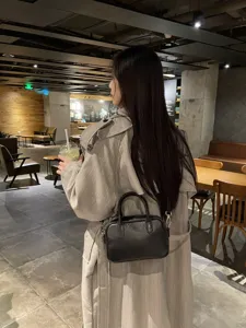 Vue de détail d'un sac Boston en cuir véritable noir, sac à bandoulière rétro pour femmes.
