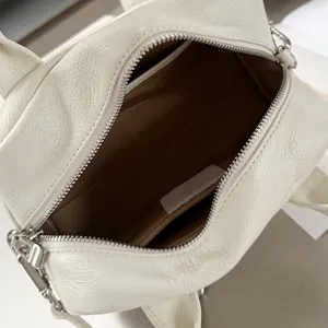 Detailed view of the white leather Boston handbag interior, showing soft cowhide texture and zipper.