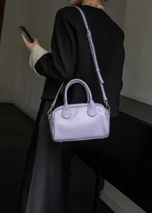 Lavender leather Boston bag detail showing soft texture, top handles, and adjustable strap.