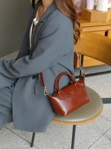 Vintage genuine leather crossbody bag for women, elegant top handle tote with adjustable strap.