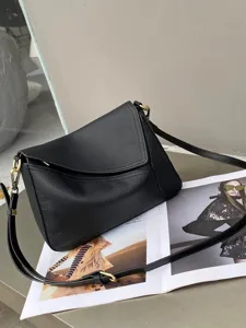 Classic black leather shoulder bag with envelope flap design, versatile minimalist cross-body style.