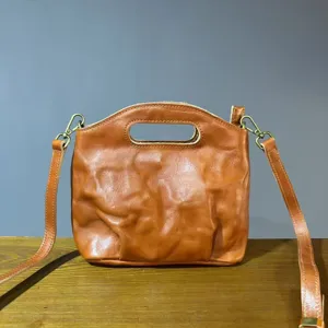 Detail view of vintage genuine leather women handbag, retro brown shoulder bag with handle.