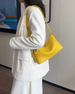 Elegant yellow leather underarm shoulder bag detail, featuring chic metal clasp and smooth grain.