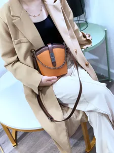 Genuine leather color-contrast bucket bag detail showcasing trendy chain and metal lock design.