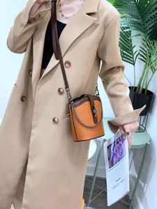 Stylish leather bucket bag with color blocking, chain strap, and elegant daily crossbody design.