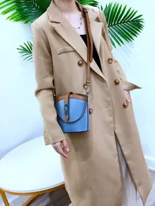 Detail view of stylish genuine leather colorblock bucket bag with metal chain strap.