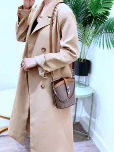 Leather bucket bag detail showing contrast color design, stylish chain strap and premium leather.