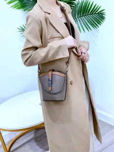 Genuine leather color-block bucket bag detail showing stylish chain strap and lock design.