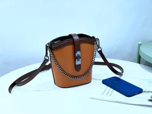 Detailed close-up view of trendy genuine leather color-block bucket bag with metal chain.