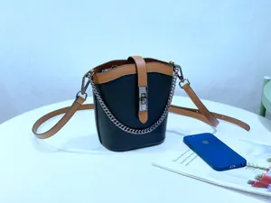 Genuine leather color-blocking bucket bag detail showing metal chain strap and lock closure.