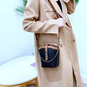 Stylish leather bucket bag with contrast color design, chain strap, and elegant cross-body look.