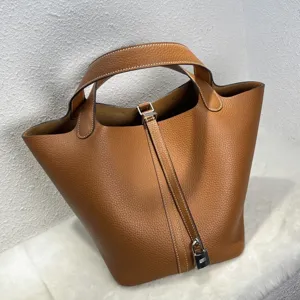 Sac seau en cuir haut de gamme fait main avec poignées et cadenas élégant pour un style chic.