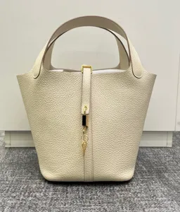 Vue détaillée du sac seau en cuir véritable avec fermeture à cadenas et poignée élégante.