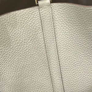 Gros plan sur la texture du cuir de vachette haut de gamme avec fil ciré cousu main.