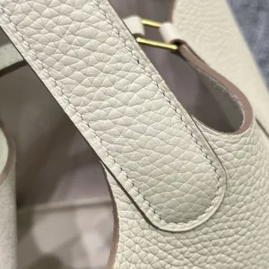 Vue detaillee du sac seau en cuir veritable avec coutures cire blanche et quincaillerie.