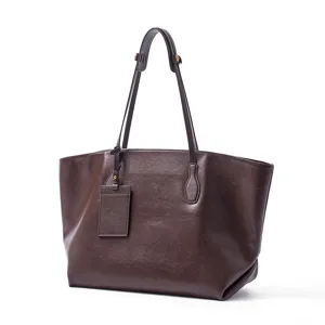 Dark brown leather tote bag detail view, featuring minimalist style and slender double straps design.