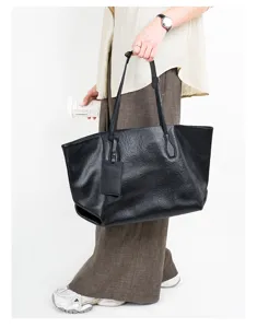 Black genuine leather tote bag for women, large capacity shoulder commuting bag detail.