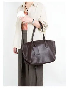 Detail view of a brown leather tote bag with double straps and minimalist design for commute.