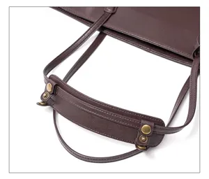 Close-up detail of premium brown leather tote bag handle, durable metal snap button and strap.