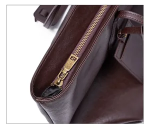 Leather tote bag zipper detail shot showing premium dark brown cowhide texture and vintage hardware.