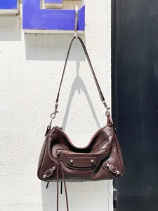 Sac porté épaule en cuir marron foncé avec clous métalliques, franges et design vintage.