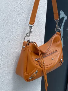 Vue détaillée du sac à main de moto en cuir orange avec clous métalliques classiques et fermetures.
