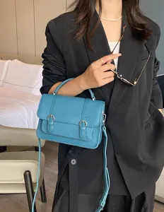 Blue leather satchel bag for women, top handle messenger with double buckle straps.