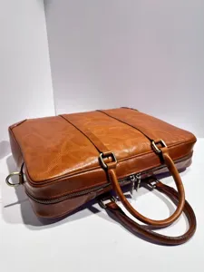 Detalle de primer plano de maletín de cuero marrón vintage, bolso de negocios clásico.