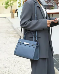 Détail de sac à main bandoulière en cuir bleu, élégant fourre-tout structuré avec fermoir métal.