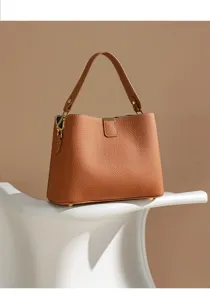 Detailed view of the elegant brown leather handbag showing premium texture and gold hardware.