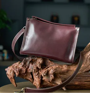 Vintage dark red leather crossbody bag detail, premium vegetable-tanned cowhide style.