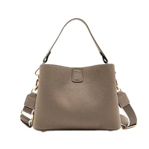 Stylish grey leather crossbody bag for women, featuring a top handle and wide strap.