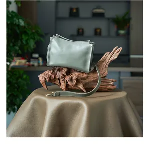 Detailed view of vintage vegetable-tanned leather crossbody bag in stylish grey-green.