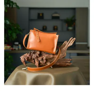 Detail view of the vintage vegetable-tanned leather crossbody bag, showing fine texture and craftsmanship.