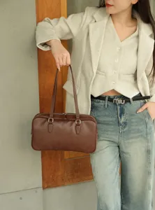 Detail view of vintage brown genuine leather shoulder bag, versatile underarm handbag style.