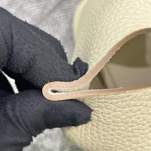 Vue détaillée de la tranche en cuir avec fil ciré cousu main et finition de bord propre.