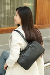 Detailed view of the black leather underarm shoulder bag worn by model, showing texture and hardware.