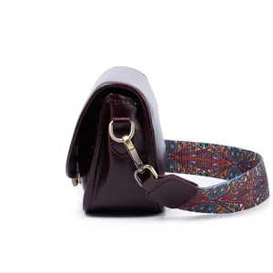 Retro leren dames zadel tas zijkant detail, brede geweven riem, modieuze koeienhuid schoudertas.