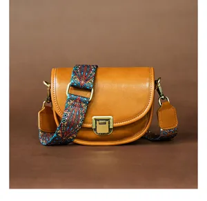 Vintage bruine lederen schoudertas voor dames met kleurrijke etnische brede riem en gesp.