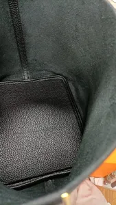 Vue intérieure détaillée d'un sac-seau en cuir noir montrant une texture de qualité.