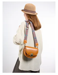 Detailoverzicht van vintage lederen dames zadel-tas met brede etnische schouderriem.