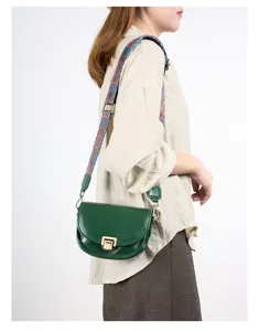 Gedetailleerd overzicht van de retro groene lederen zadeltas met brede etnische riem en slot.