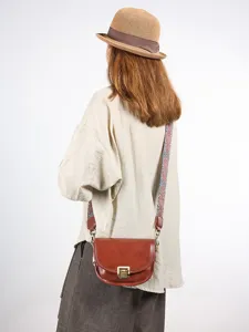 Vintage bruine lederen zadeltas voor dames met brede riem, stijlvolle crossbodytas hoofdaanzicht