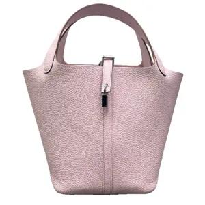 Sac seau en cuir rose, design classique cousu main avec fermoir en métal pour usage quotidien.