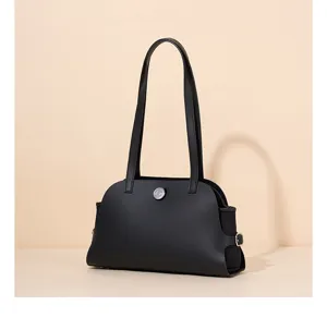 Nahaufnahme der schwarzen Lederschultertasche mit ihrem einzigartigen geschwungenen Design.