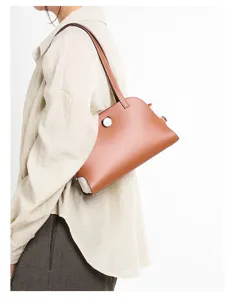 Detailaufnahme einer braunen Schultertasche aus echtem Leder, minimalistisches Design für Arbeit.