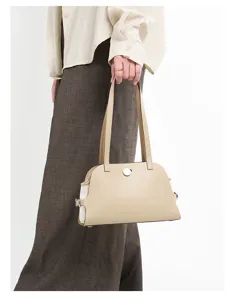 Nahaufnahme der minimalistischen beigen Schultertasche aus Leder mit Form und Verschluss.