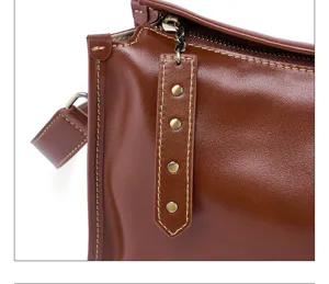 Detailed close-up of vintage vegetable-tanned leather women shoulder bag with fine stitching.