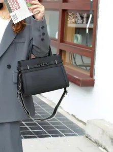 Sac a main noir en cuir veritable avec fermoir tournant et bandouliere pour les femmes.
