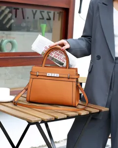 Élégant sac à main en cuir de vachette texturé Togo avec fermeture métallique et bandoulière.